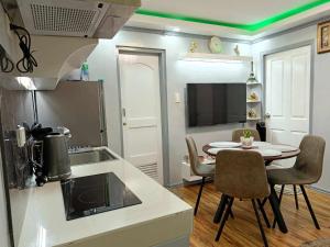 a kitchen with a table and a kitchen with green lighting at Davao condo unit 204 in Davao City