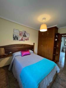 ein Schlafzimmer mit einem Bett mit einer blauen und violetten Decke in der Unterkunft El Hoyaco in Los Espejos de la Reina
