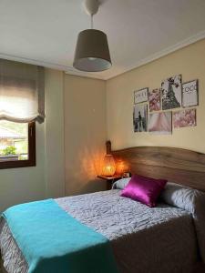 ein Schlafzimmer mit einem Bett mit einem lila Kissen darauf in der Unterkunft El Hoyaco in Los Espejos de la Reina