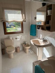 ein weißes Bad mit einem WC und einem Waschbecken in der Unterkunft El Hoyaco in Los Espejos de la Reina