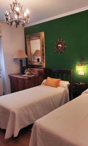 a green room with two beds and a mirror at Casa de Aldea La Pescal in La Pescal