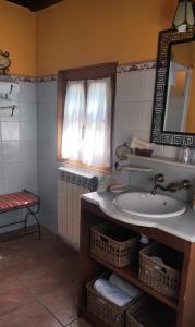 ein Bad mit einem Waschbecken und einem Spiegel in der Unterkunft Casa de Aldea La Pescal in La Pescal