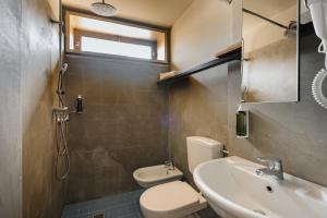 Un baño con inodoro, lavabo y ducha. en 'RE-Dama Hostel, en Florencia