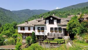 コヴァチェヴィカにあるКъща за гости Далеч от моретоの山を背景にした丘の上の家