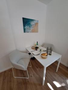 a white table and chair in a room with a table and a plate of food at Gemütliche helle Ferienwohnung in Dresden