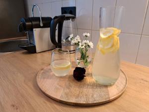 Uma garrafa de limonada e dois copos no balcão. em Gemütliche helle Ferienwohnung em Dresden