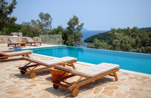 a swimming pool with chaise lounge chairs and a swimming pool at Villa Dara and Todd in Sivota