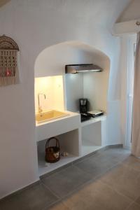 a white kitchen with a sink and a counter at il Marinero mandrakia in Mandrakia +11 photos
