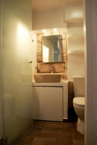 a bathroom with a sink and a toilet and a mirror at il Marinero mandrakia in Mandrakia