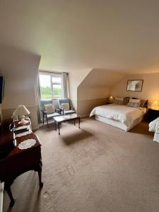 sypialnia z łóżkiem, krzesłem i stołem w obiekcie Faul House w mieście Clifden