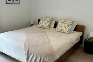 Una cama con sábanas blancas y almohadas en un dormitorio en Dreaming Amongst the Palms, en Mission Viejo