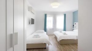 Habitación con 2 camas y espejo. en Alicante Hotel - Adult Only, en Bozcaada