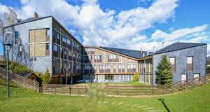 um grande edifício com uma cerca em frente em Campus Cerdanya em Puigcerdà