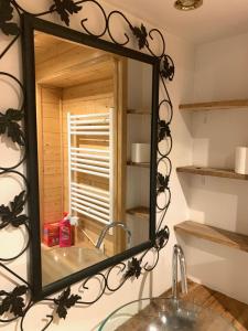 La salle de bains est pourvue d'un miroir et d'un lavabo. dans l'établissement maison de vigneron, à Mareugheol