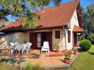 Un patio con una mesa y sillas frente a una casa. en Maria Andrea House, en Balatonkeresztúr