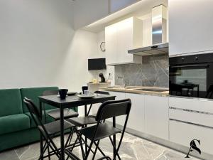 a kitchen with a table and chairs and a green couch at Dimora in pieno centro in Matera