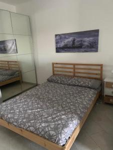 - une chambre avec un lit et un miroir dans l'établissement Villino Monte Sant'Angelo, à Otrante