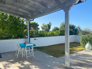 un pergolato con tavolo e sedie blu su un patio di Villino Monte Sant'Angelo a Otranto