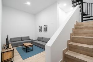 sala de estar con sofá y escaleras en amplio duplex reformado, en Madrid