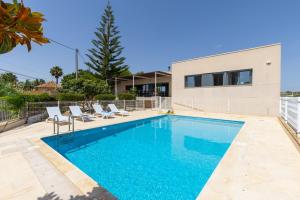 a swimming pool with chairs and a house at Sunshine Villa by Fidalsa in Los Montesinos
