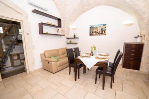 een eetkamer met een tafel en stoelen en een bank bij Terrazza Mazzini - Suite Porta Piccènne in Cisternino