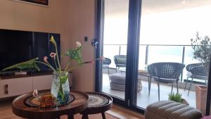 Novi Hills في هرسك نوفي: غرفة معيشة مع إناء من الزهور على طاولة