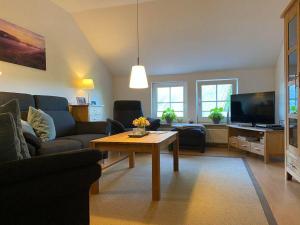 ein Wohnzimmer mit einem Sofa und einem Tisch in der Unterkunft Ferienwohnung Heideschmetterling in Hermannsburg