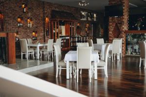 a dining room with white tables and white chairs at Hotel Panorama in Gjakove