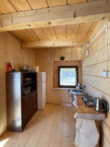 a kitchen with wooden walls and a wooden floor at Domek Oźna płoscyna in Rajcza