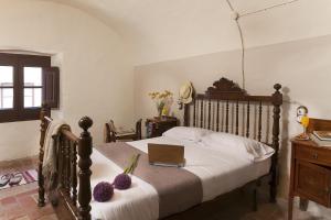 een slaapkamer met een bed met een laptop erop bij Can Barrina in Ventalló
