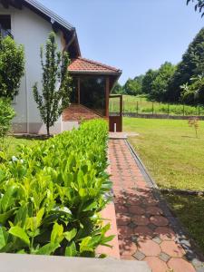 a garden with a brick walkway in front of a building at Vikendica Majevicka Oaza in Tuzla