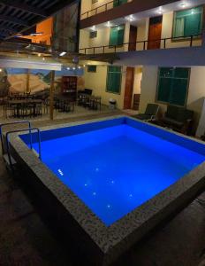 a large blue swimming pool in a building at Hostel Boulevard in Ica