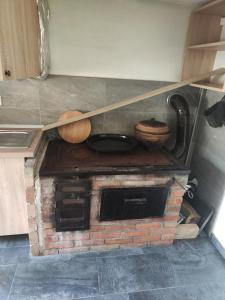 a kitchen with two wooden utensils on top of a brick oven at Vikendica Majevicka Oaza in Tuzla