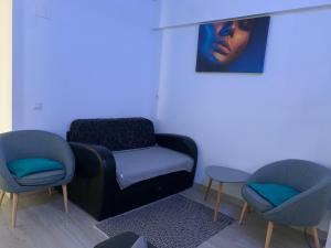Black&White Suites في كرايوفا: غرفة بها كرسيين وكرسي وطاولة