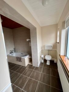 een badkamer met een bad en een toilet bij Faul House in Clifden