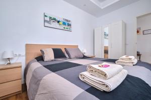 a bedroom with a large bed with towels on it at Apartments Vegueta Suite in Las Palmas de Gran Canaria