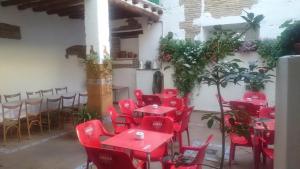 a group of red tables and chairs in a room at Hostal El Centro in Huesca