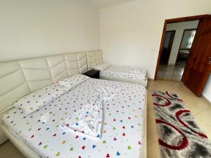 1 dormitorio con 2 camas individuales y alfombra en Chateau Sukaj, en Ljaknasi