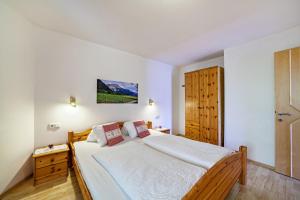 a bedroom with a large bed with white sheets at Mühlanderhof Apt Endkopf in Resia