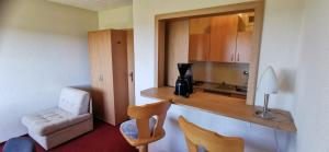 a room with a kitchen with a desk and a chair at Apartment mit Balkon in Kempfeld
