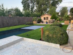 een achtertuin met een zwembad en een tuin bij La Maison d'Arc Chambres et Tables d'Hôtes in Frasnes-lez-Anvaing