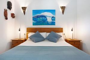 Casa al volcán de Lajares في لاجاريس: غرفة نوم بسرير كبير مع وسائد زرقاء