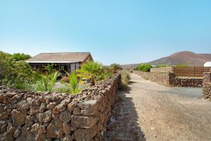 Casa al volcán de Lajares في لاجاريس: جدار عازل حجري بجانب منزل