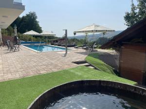 a swimming pool with a pond in the middle of a yard at Hotel Relax Sovata in Sovata