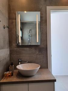 a bathroom with a bowl sink and a mirror at Terrazza Suites in Paphos City