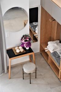 a bedroom with a table with a mirror and a chair at La Mer Luxury Apartments in Ierissos