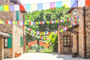 a string of colorful flags hanging between two buildings at Agriturismo Dandelion in Città della Pieve