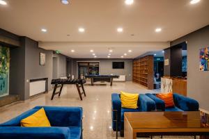 a living room with blue couches and a pool table at Gudauri Inn in Gudauri