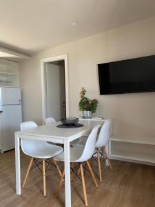 a dining room with a white table and white chairs at Mobile House KASTANJOLA in Biograd na Moru