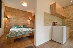 a small bedroom with a bed and a refrigerator at Ginko House in Opatija